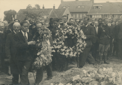 860706 Afbeelding van de begrafenisplechtigheid van L.C.P. Maagdenberg: genodigden lopen met bloemenkransen naar het ...